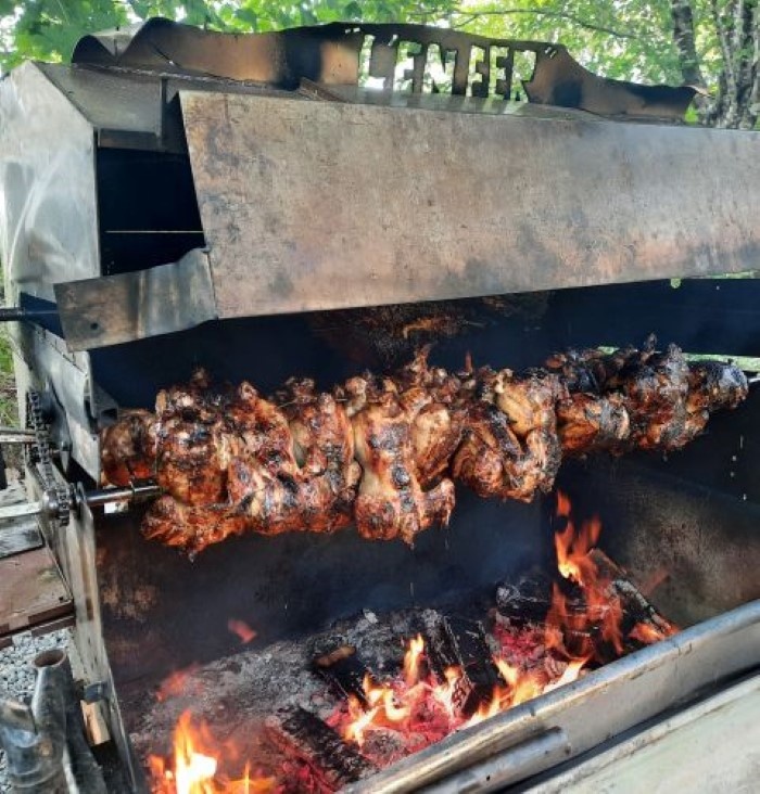 Rôtissoire de méchoui au feu de bois d'érable avec poulets grillés par Méchoui du Marquis, traiteur spécialisé au Québec pour évènements, mariages et fêtes en plein air